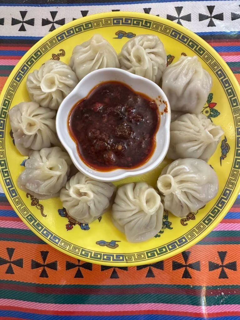 Traditional Tibetan yak momo dumplings served fresh in a bamboo steamer container